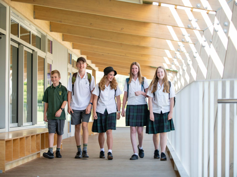 Group of students walking through classroom corridor